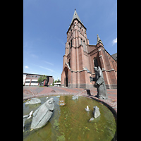 Papenburg, Stadtkirche St. Antonius, Brunnen-Skulptur 'Antonius von Padua predigt vor Fischen' vor der Kirche